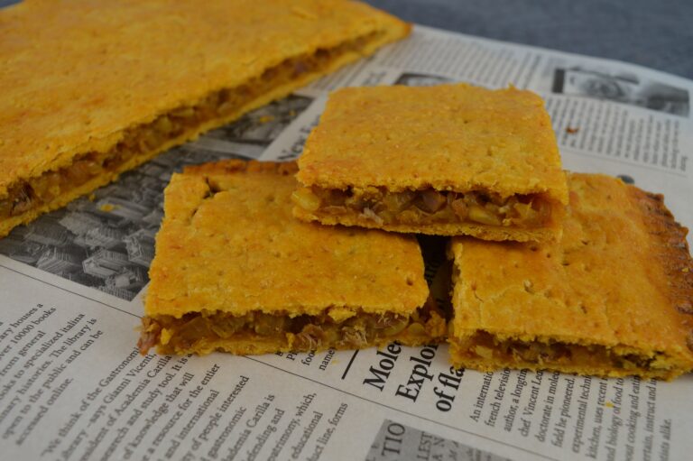 Coca amb tonyina, la receta salada típica de las Hogueras de San Juan en Alicante: masa crujiente con anís y relleno de tonyina de sorra, cebolla pochada y piñones.